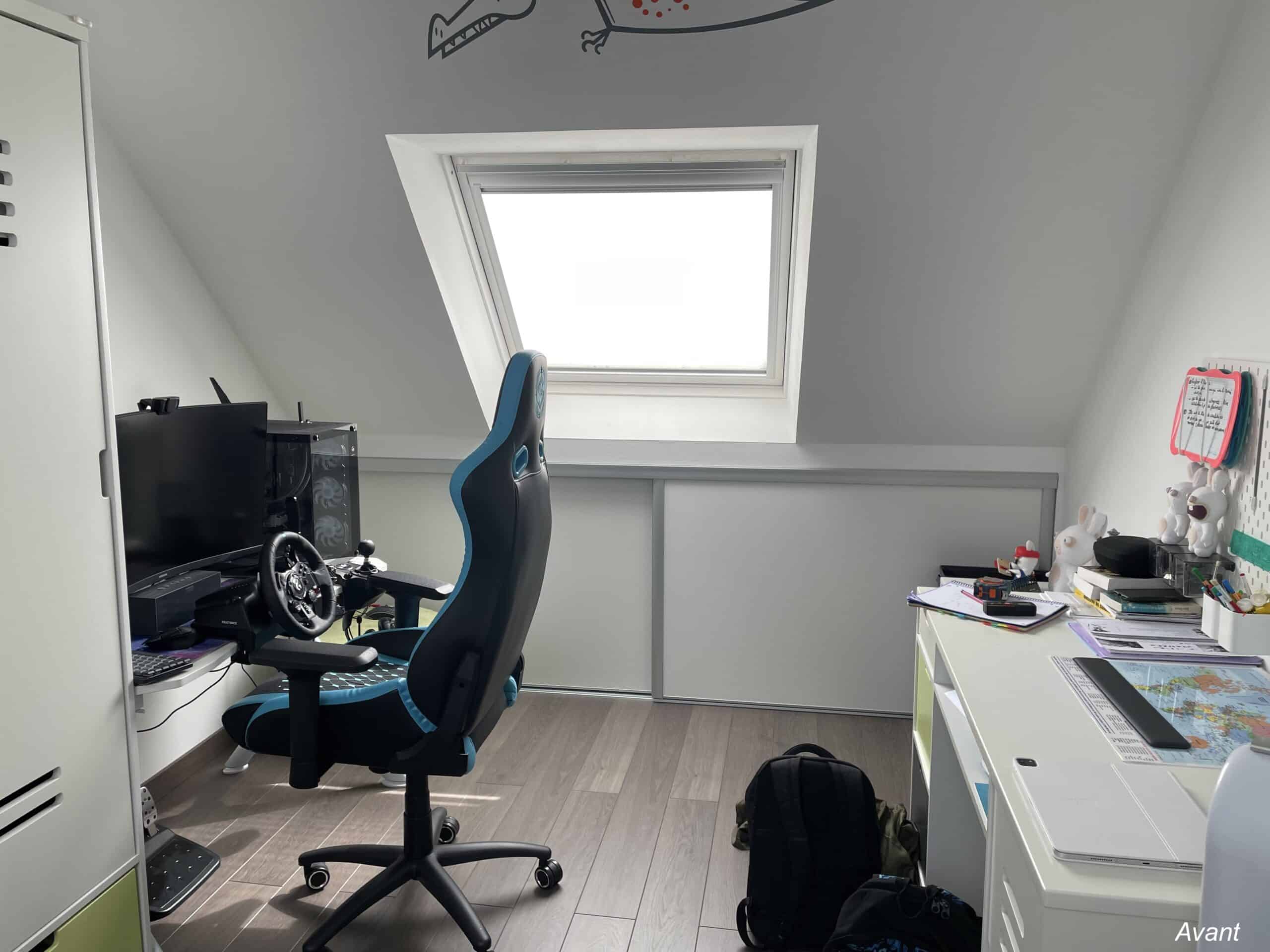 Bureau sous combles avant rénovation : setup gaming avec siège bleu, volant et fenêtre de toit lumineuse.