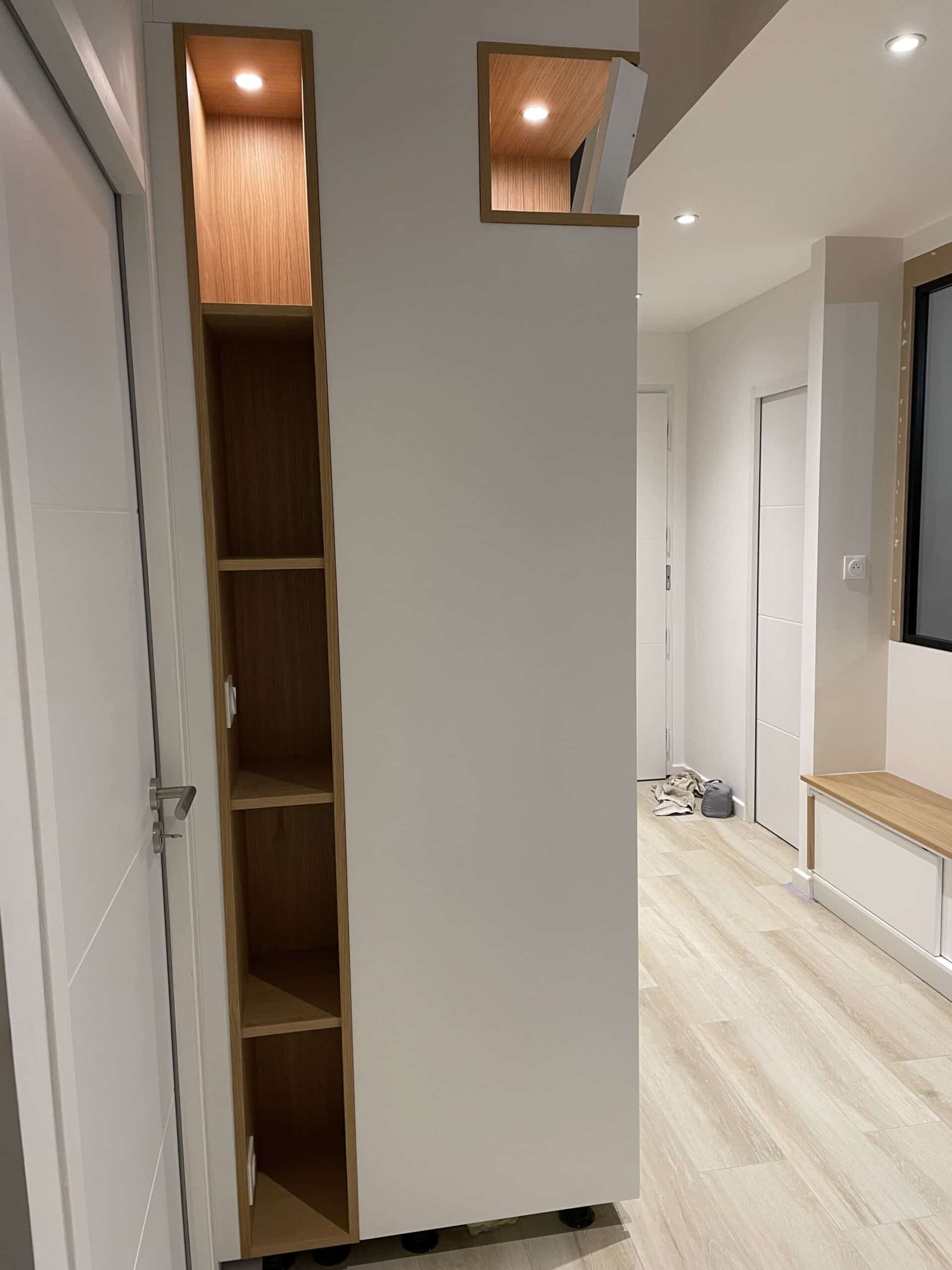 Étagères en bois encastrées avec éclairage intégré dans un couloir blanc au design moderne.