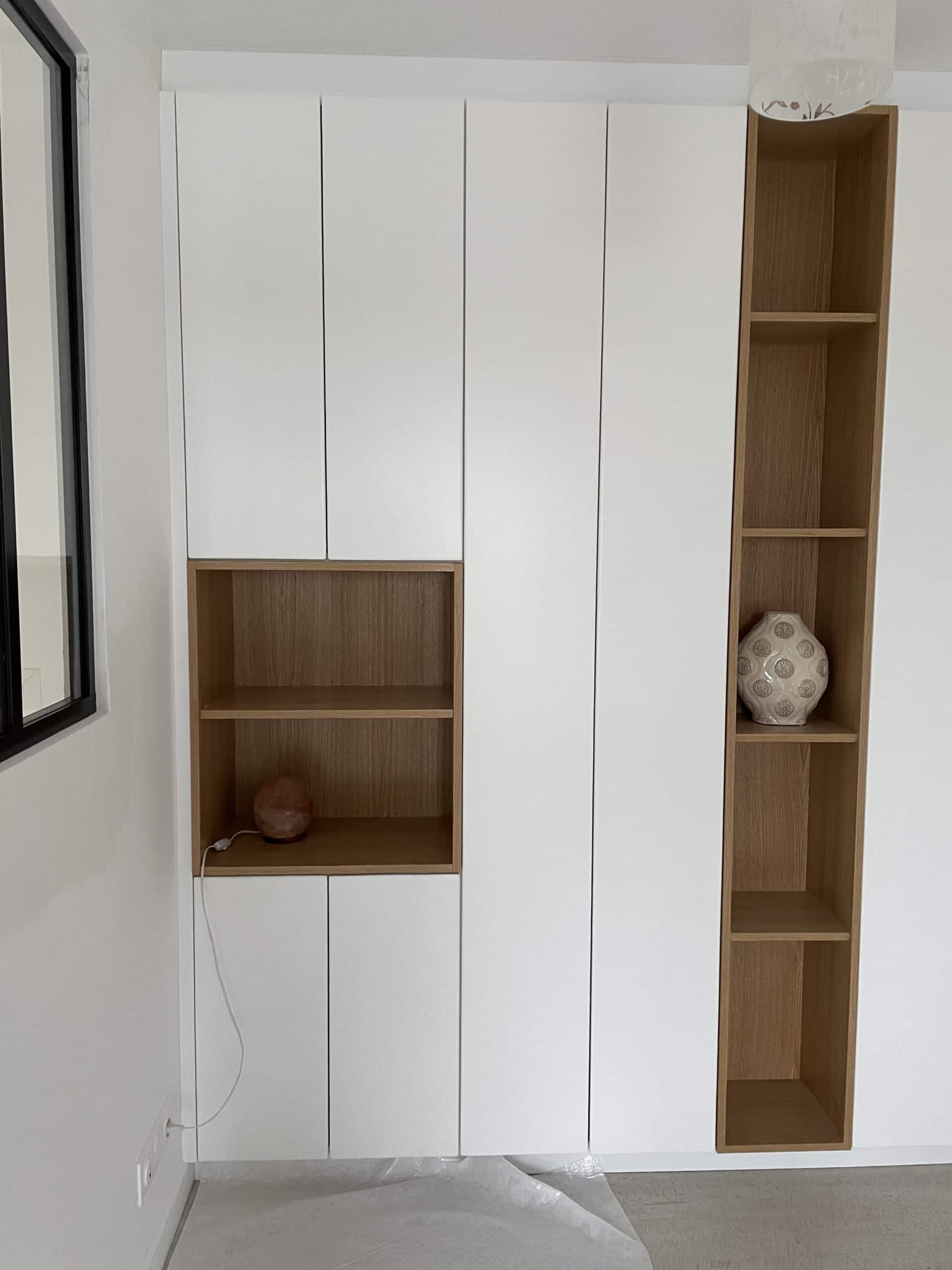 Dressing sur mesure blanc et chêne avec niches ouvertes minimalistes, lampe de sel rose et vase design.
