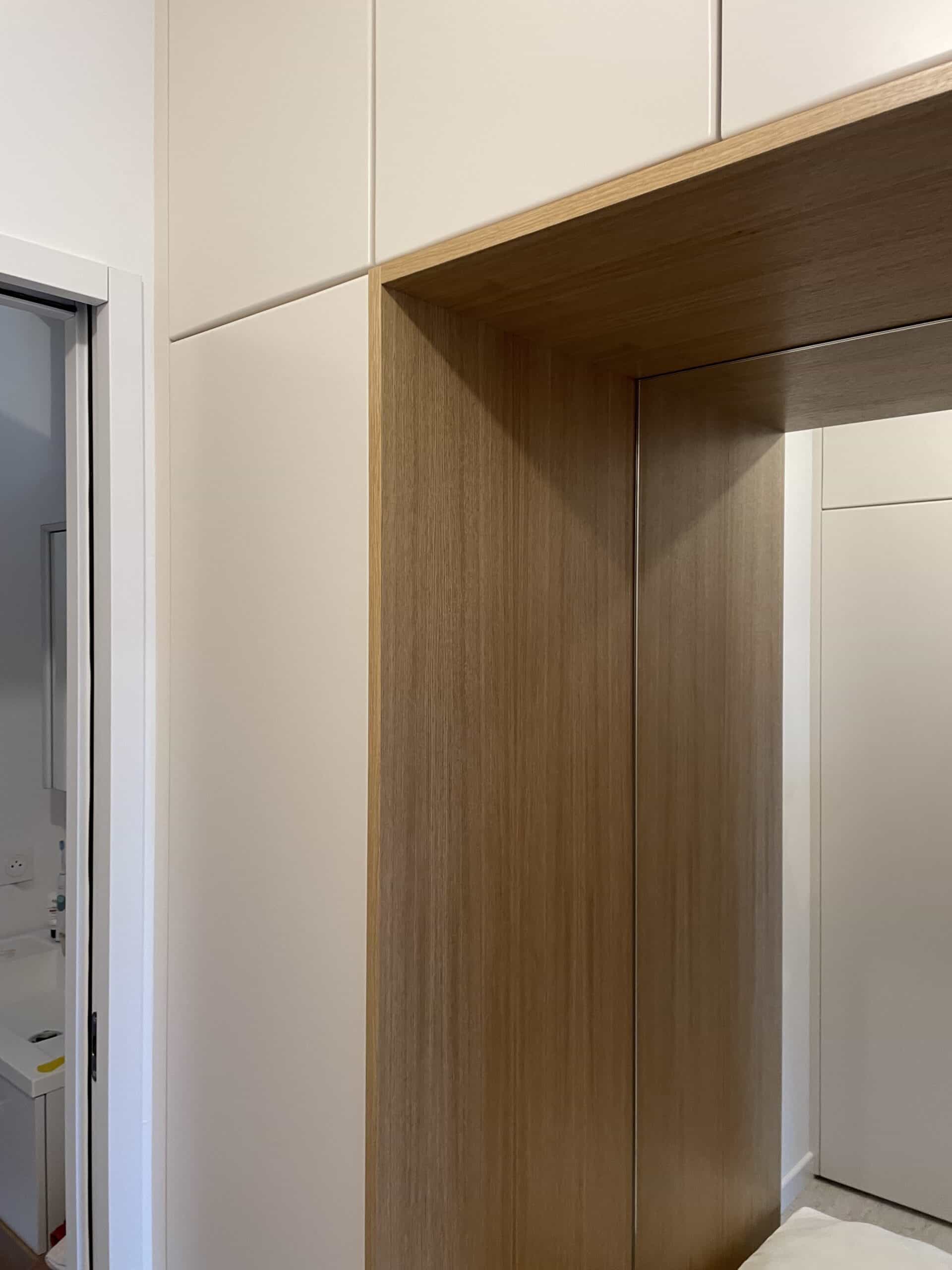 Dressing sur mesure avec portes beiges et grande niche décorative en bois de chêne clair.